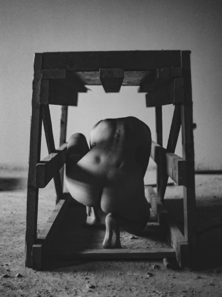 Scène éditoriale, silhouette féminine accroupie vue de dos, lumière douce.