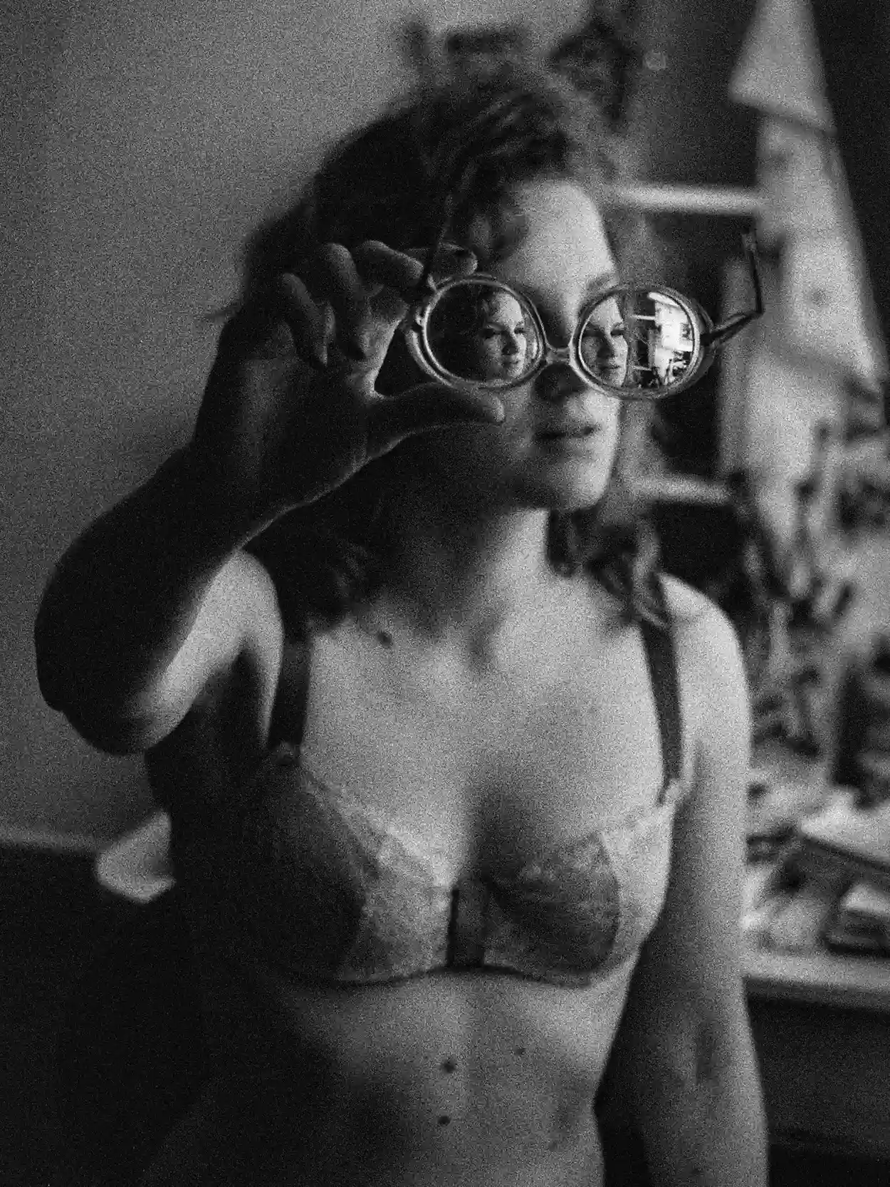 Femme en cadrage rapproché, bouche visible sous une couverture, fond sombre, éclairage frontal.