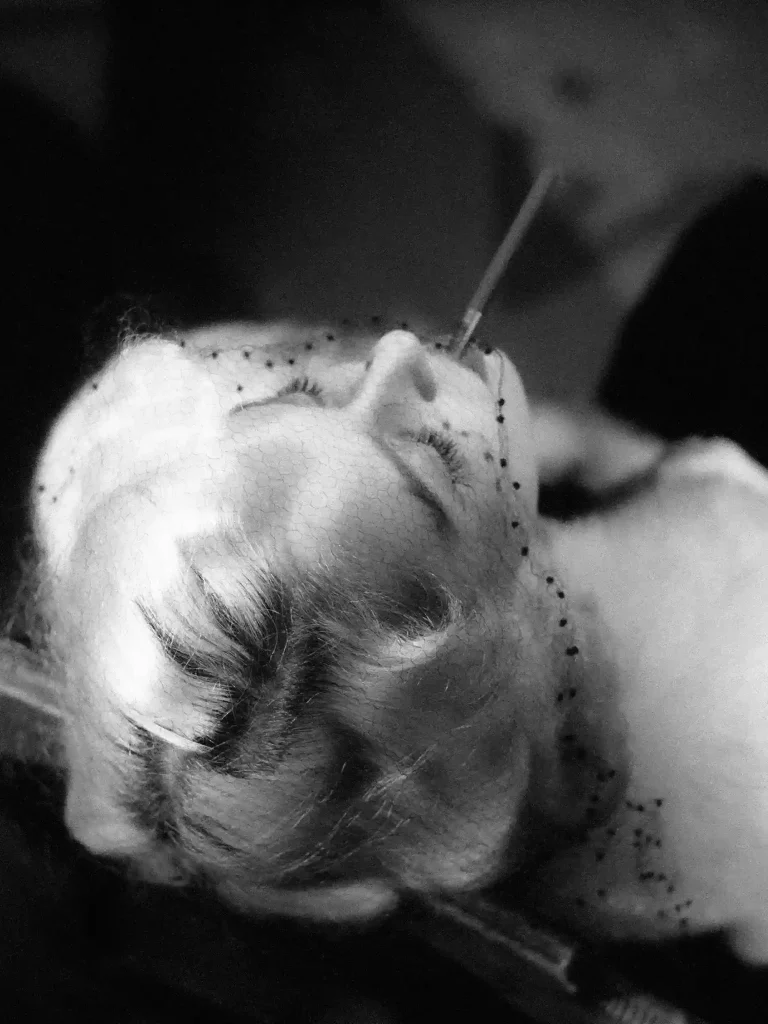 Portrait artistique en noir et blanc, femme années 50, vue de haut, geste stylisé.