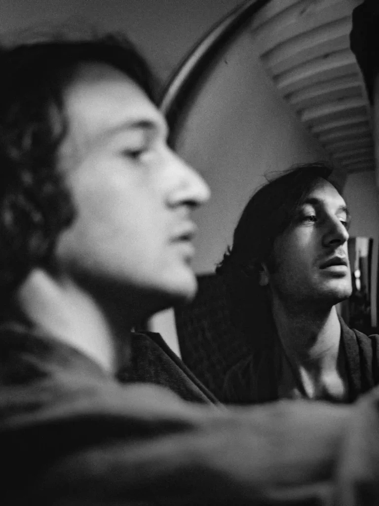 Scène éditoriale, homme se regardant dans un miroir, visible à la fois dans le reflet et de profil.