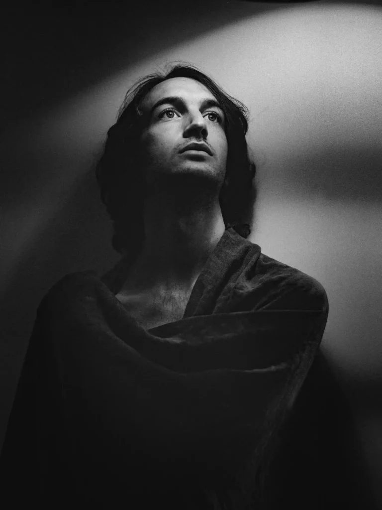 Portrait noir et blanc, homme regard dans le vide, lumière douce.