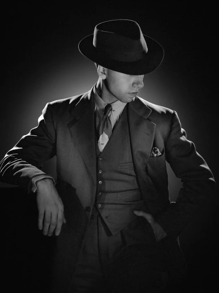 Portrait éditorial, homme au look rétro années 20, cadrage sur le buste et les jambes supérieures.