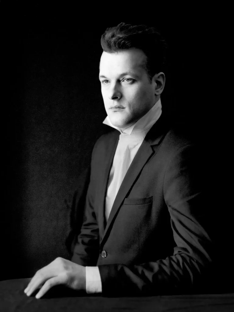 Photographie artistique, homme en costume, regard vers l’horizon, posture sobre.