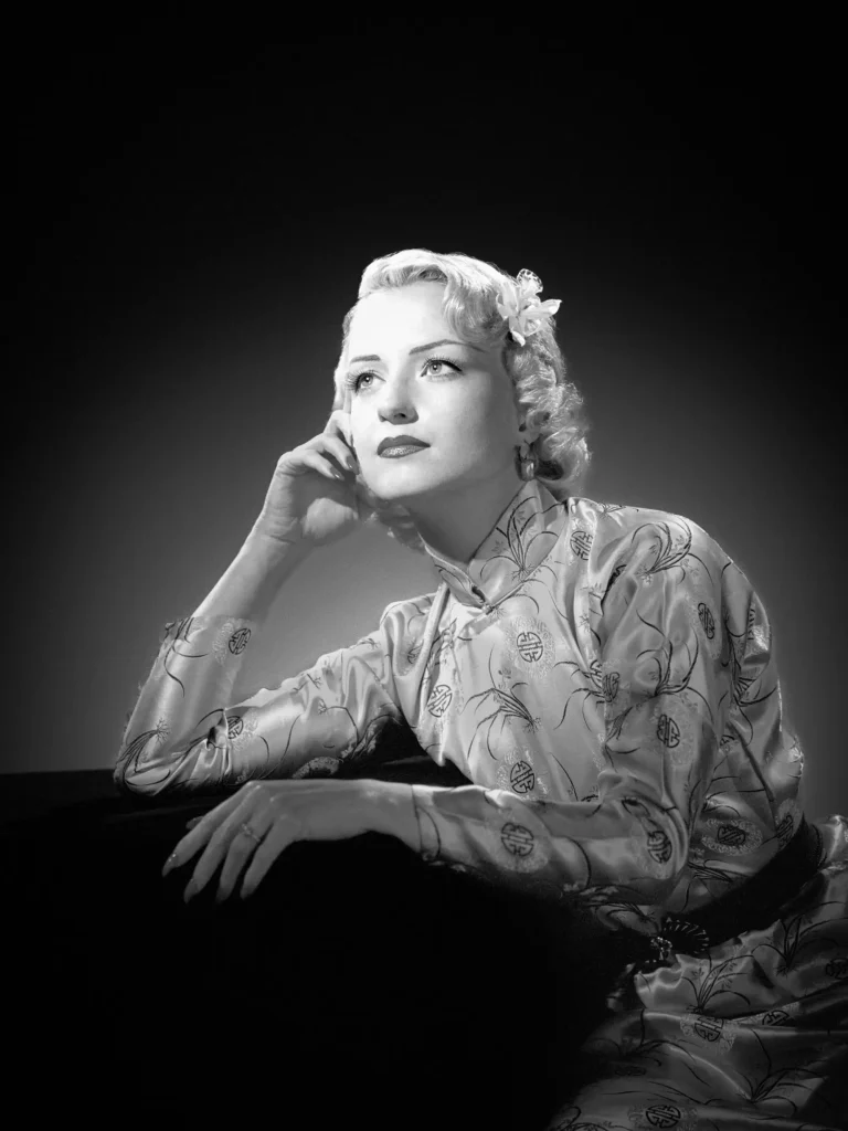 Portrait style Harcourt, femme au look années 50, regardant au loin, visage illuminé.