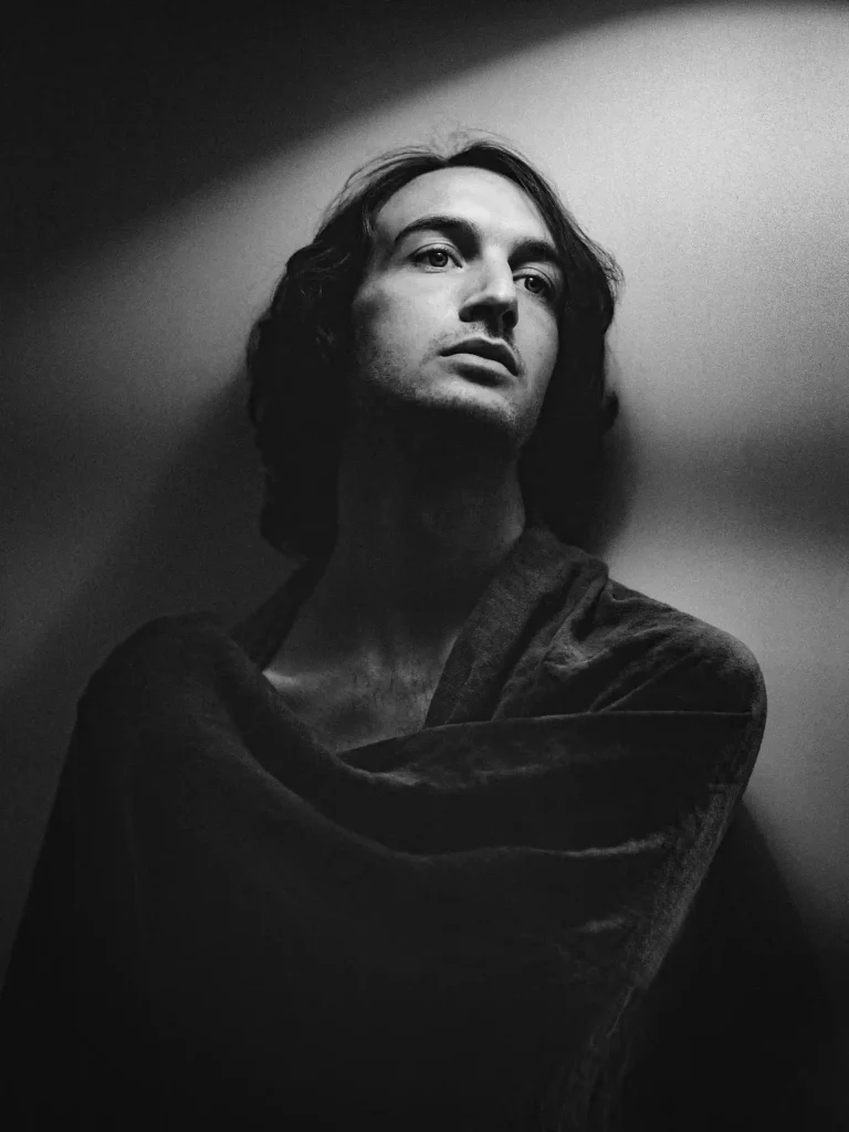 Portrait noir et blanc, homme regard dans le vide, lumière douce.