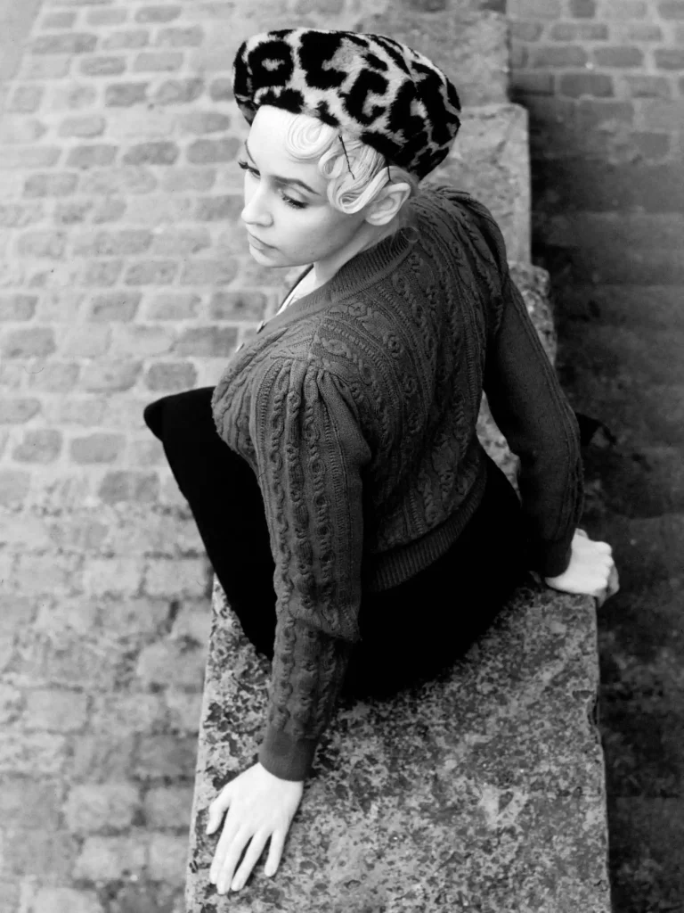 Photographie rétro en noir et blanc, femme sur les quais de scène de Paris, ambiance élégante.