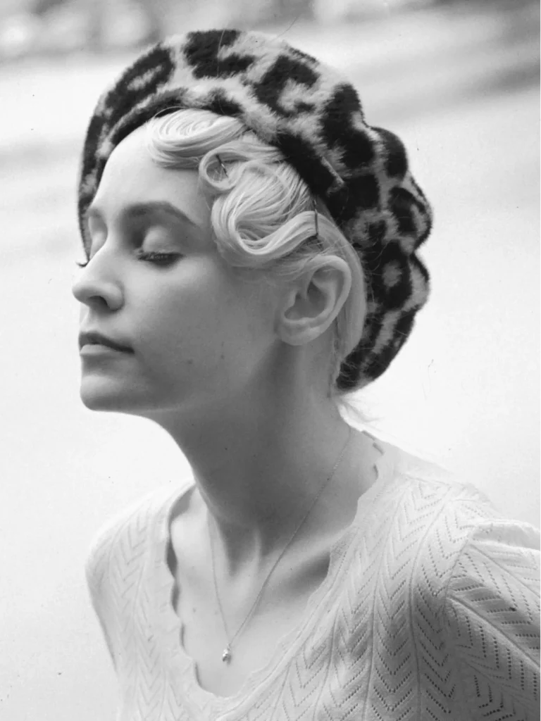 Portrait éditorial, femme vintage, yeux clos, ambiance lumineuse et douce.