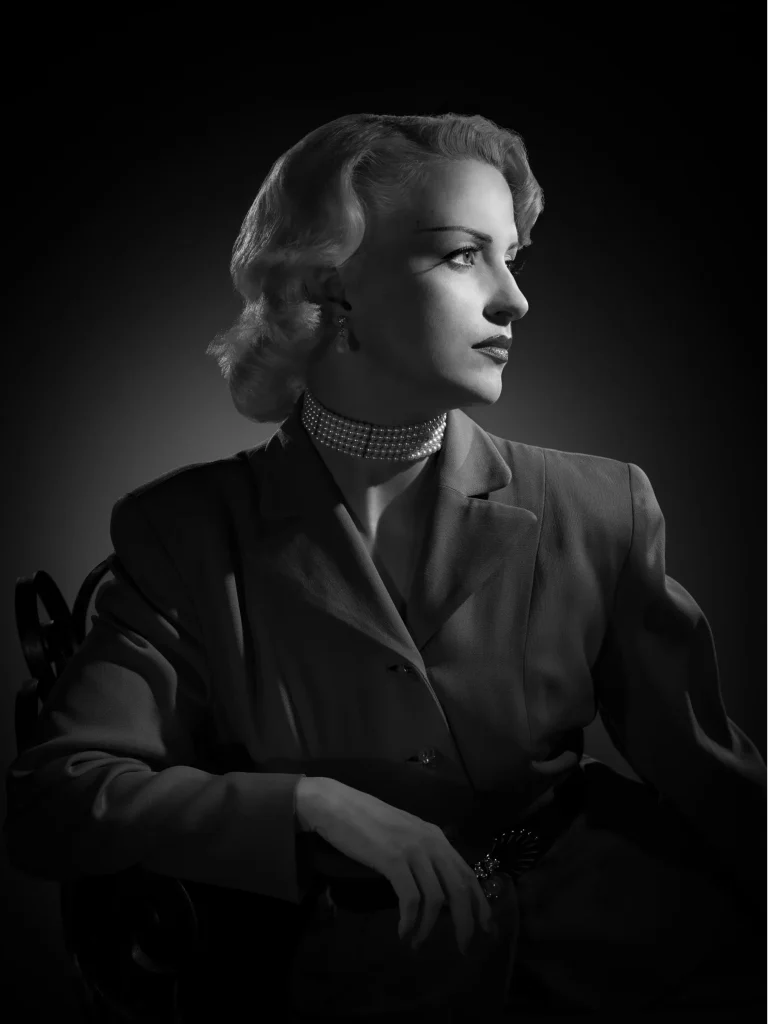 Portrait de profil d’une femme au style vintage, noir et blanc, lumière douce.